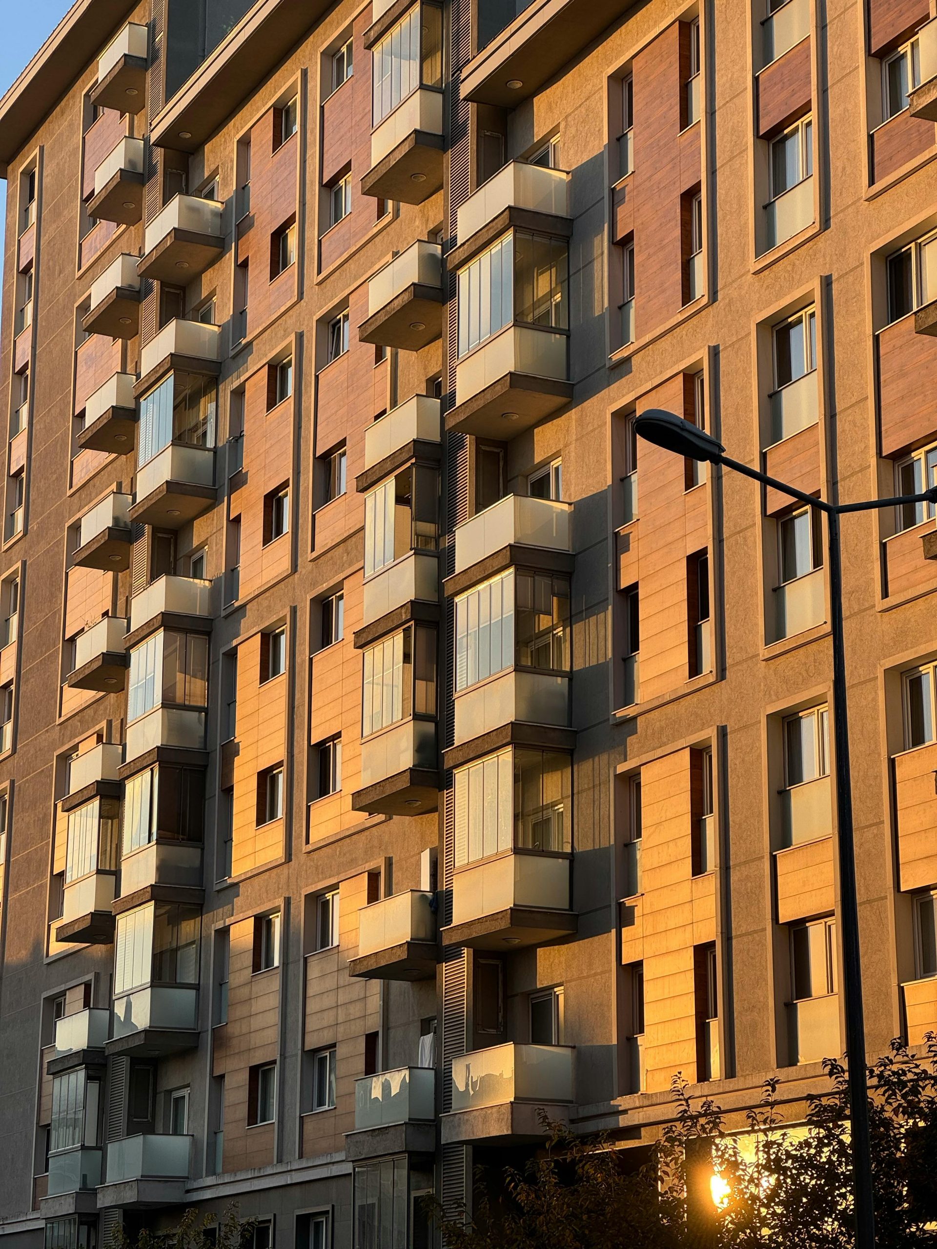 A modern apartment building facade beautifully lit by sunset light.